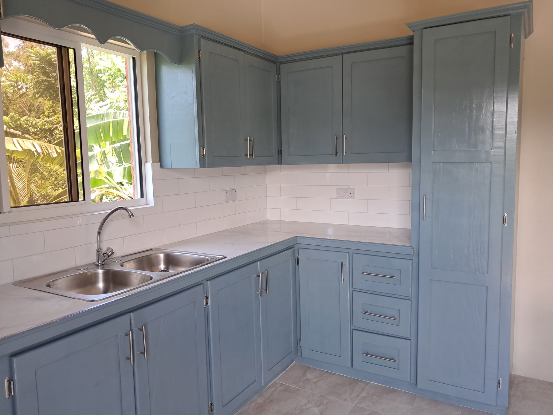 Kitchen with blue cabinetry and a bright window